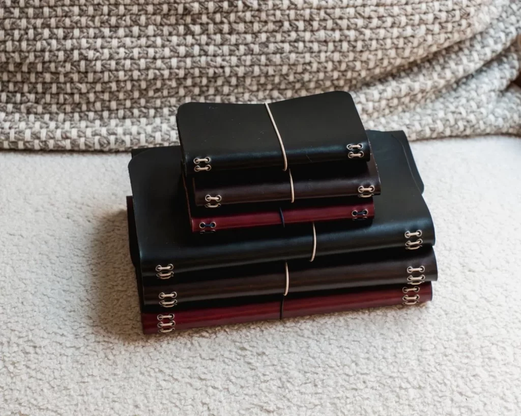 Journals de cuero notāre apilados en sofá, formatos Muse y Nomad