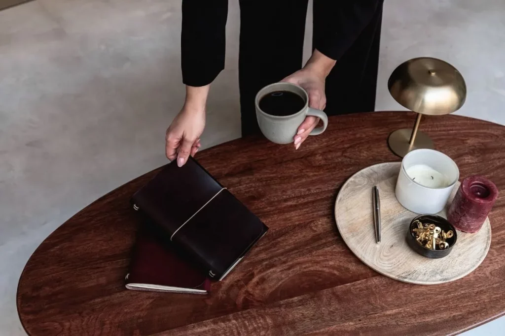 Journal de cuero notāre sobre una mesa con café, vela y detalles artesanales